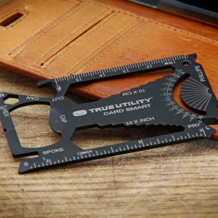 Multitool karta True Utility CardSmart 30w1 obok skórzanego portfela